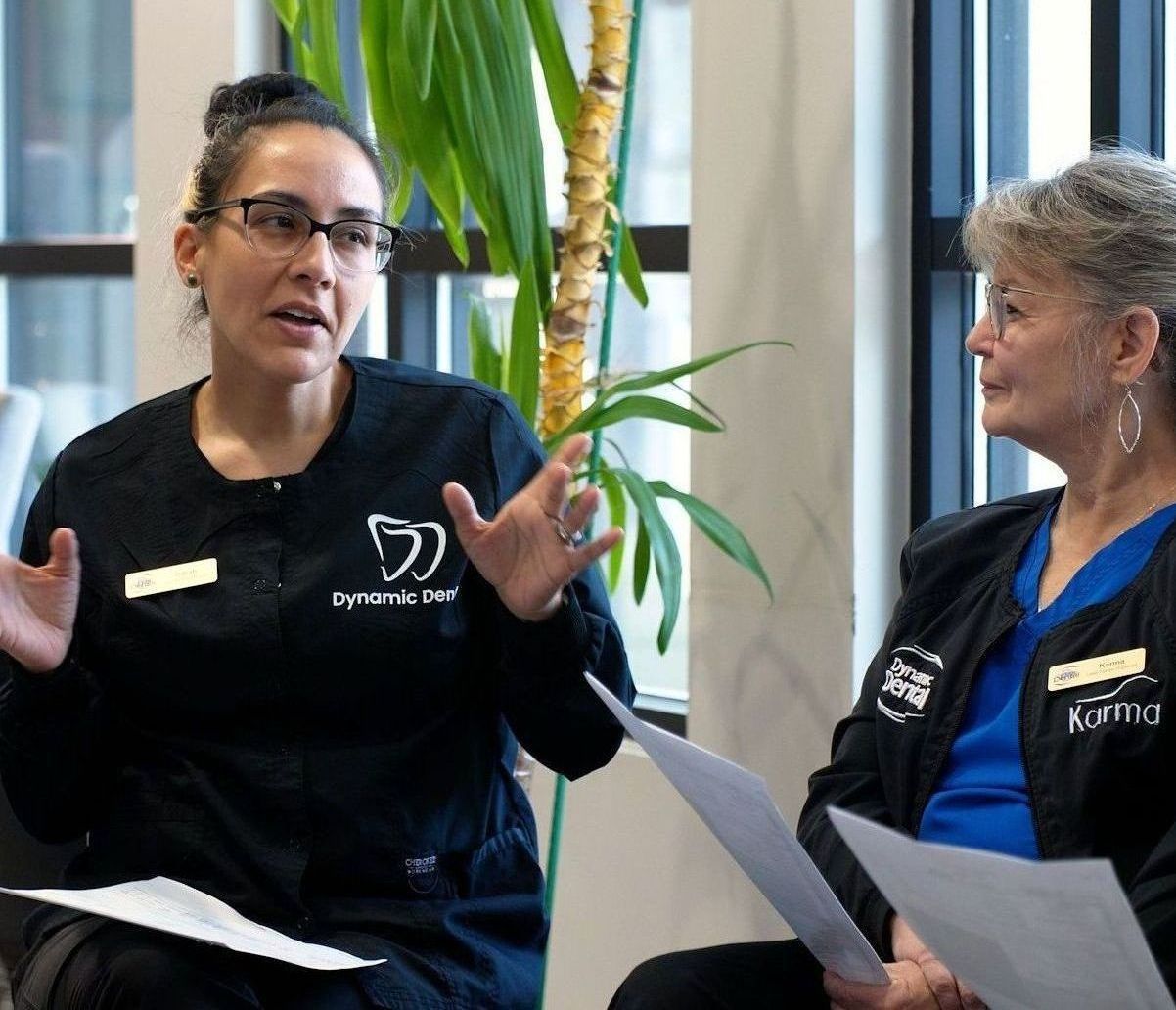 A group of women are sitting in a waiting room talking to each other.