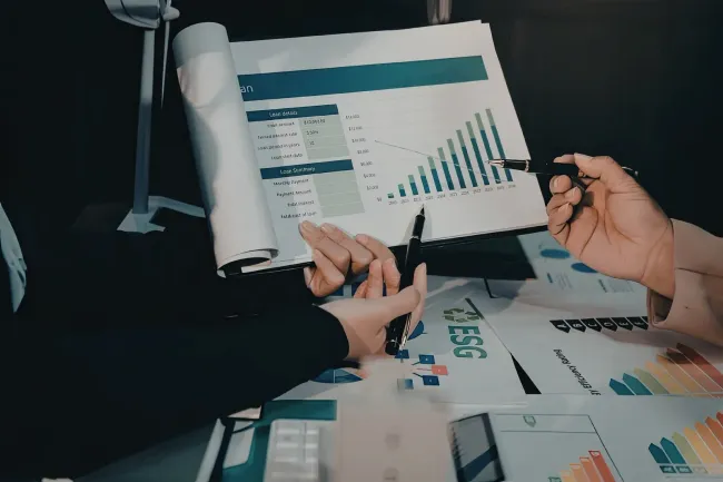 Hands reviewing printed charts and graphs during a business meeting