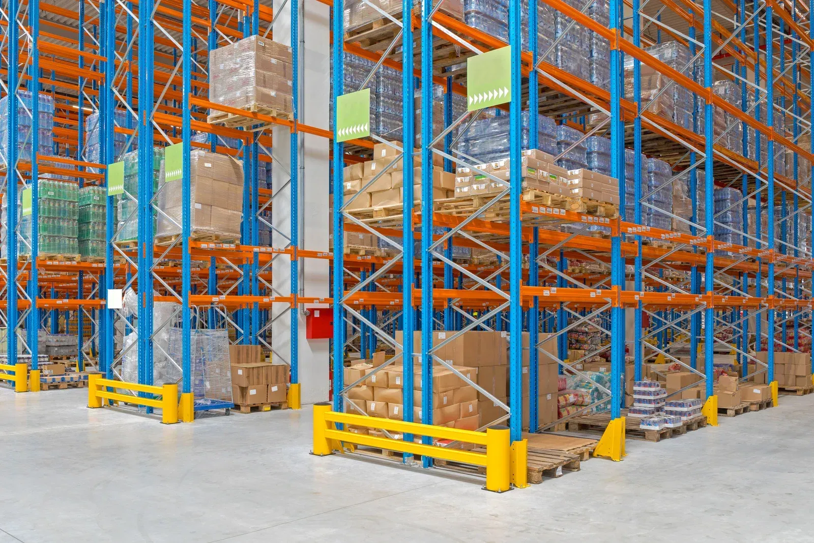 Warehouse storage racks stacked with pallets of boxes in a large industrial aisle