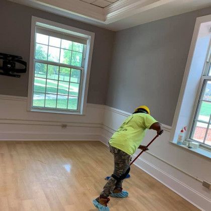 a woman is mopping the floor of a room with a mop .