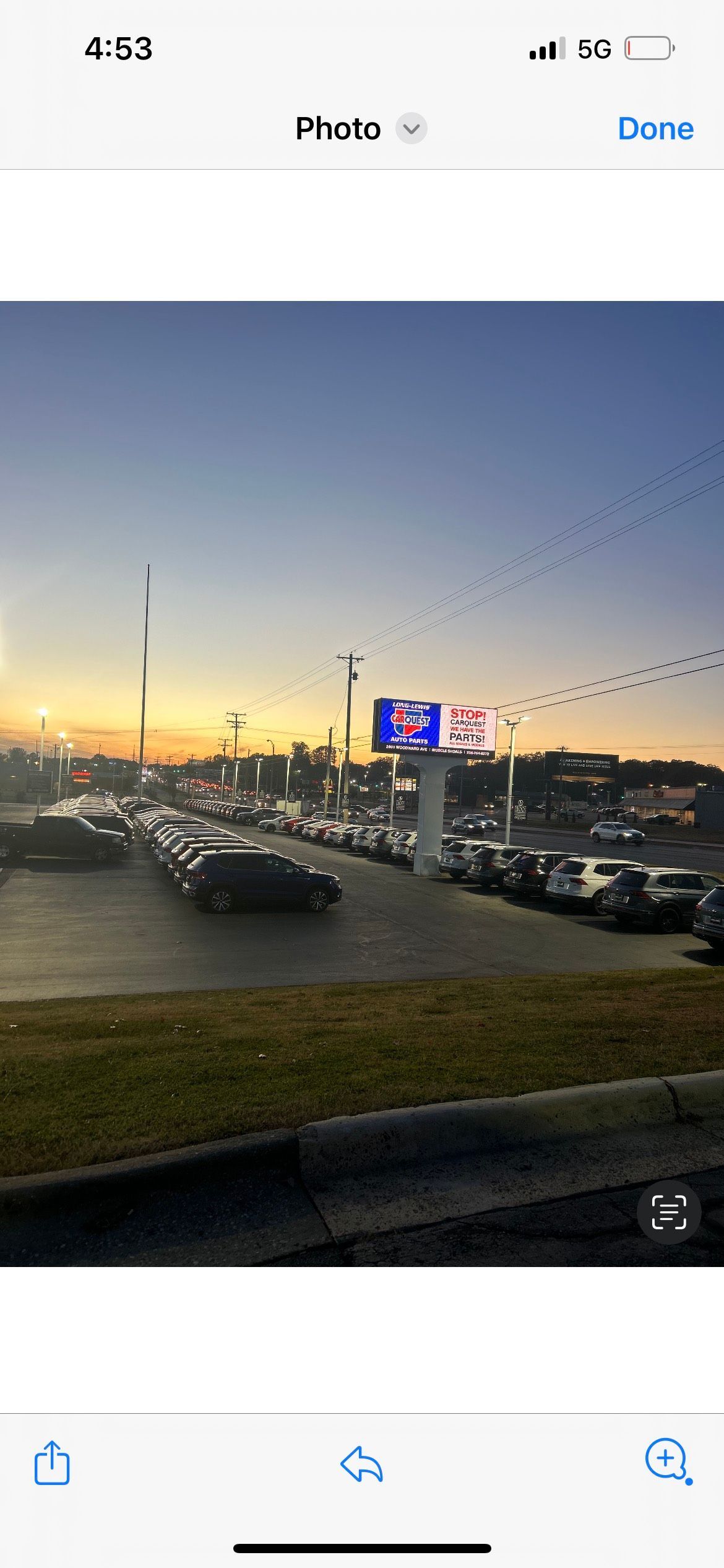 A picture of a parking lot at sunset on a cell phone.