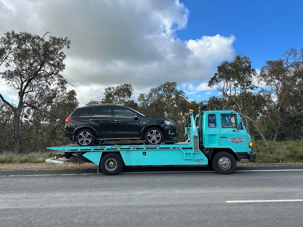 Black SUV Loaded on Truck — John Zelukovic Smash Repairs in Orange, NSW