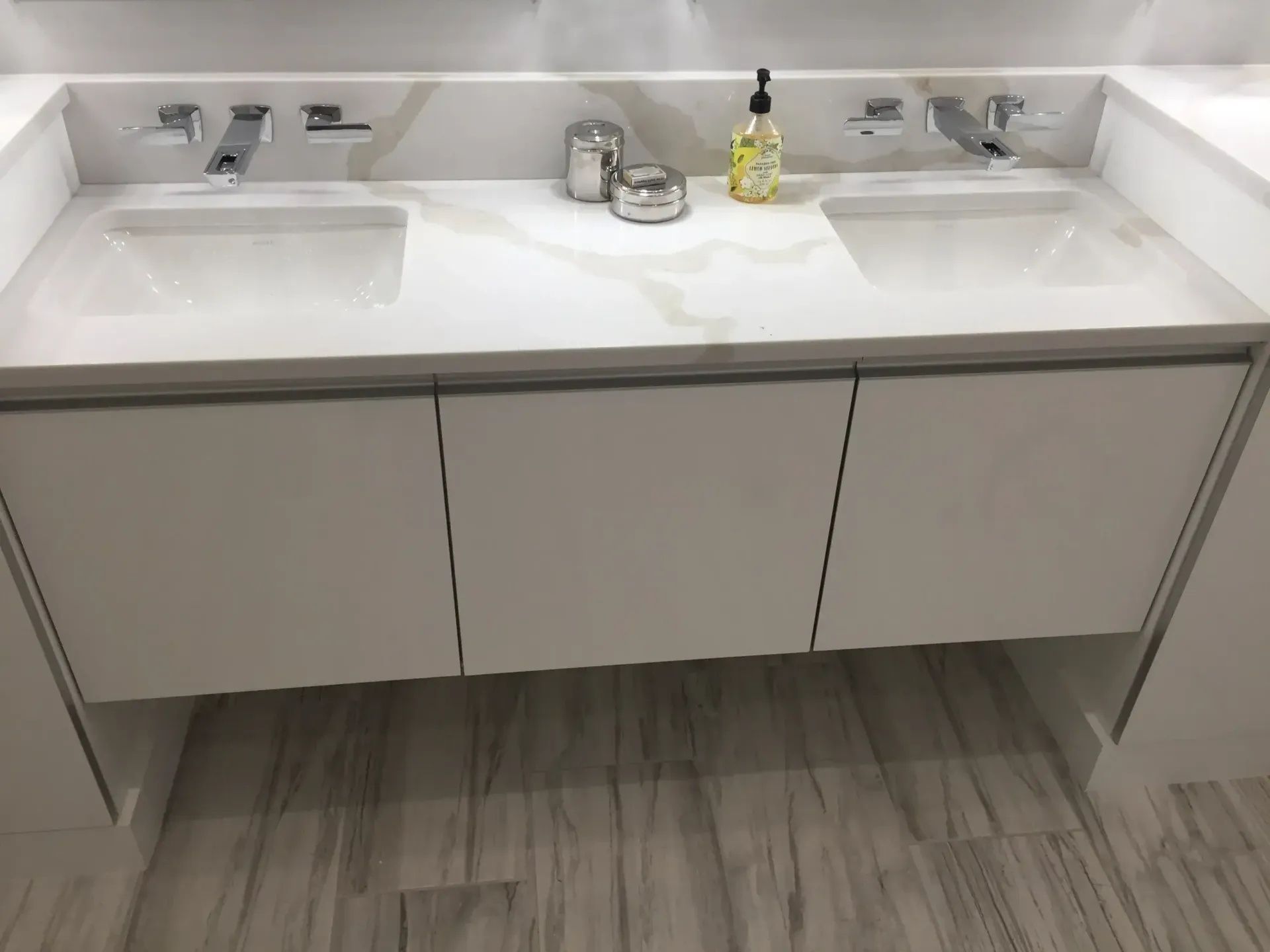 White double sink vanity with three drawers, chrome faucets, and marble countertops.