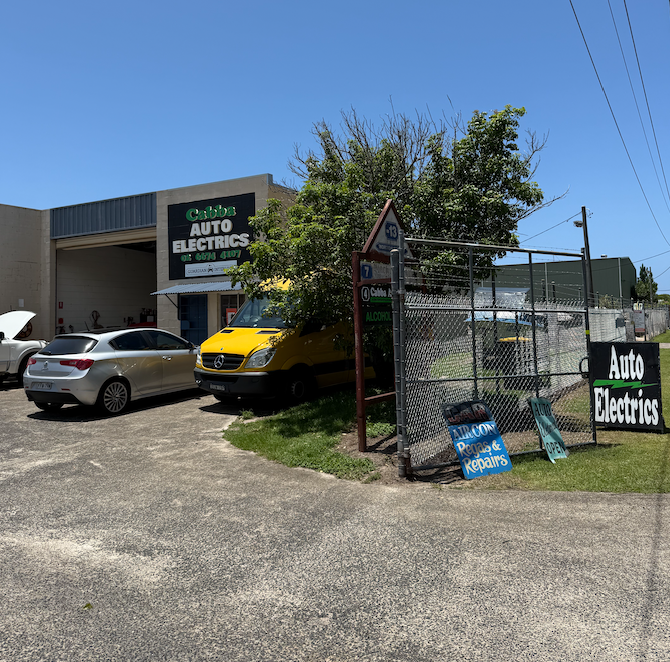 A Ute Next To A Car Both Parked In Front Of A Building— Cabba Auto Electrics In Chinderah, NSW