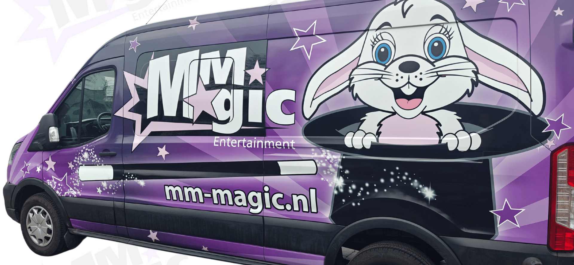 Een paarse bus met lgo MMmagic, goochelstok en een konijntje op de zijkant en de tekst mm-magic.nl