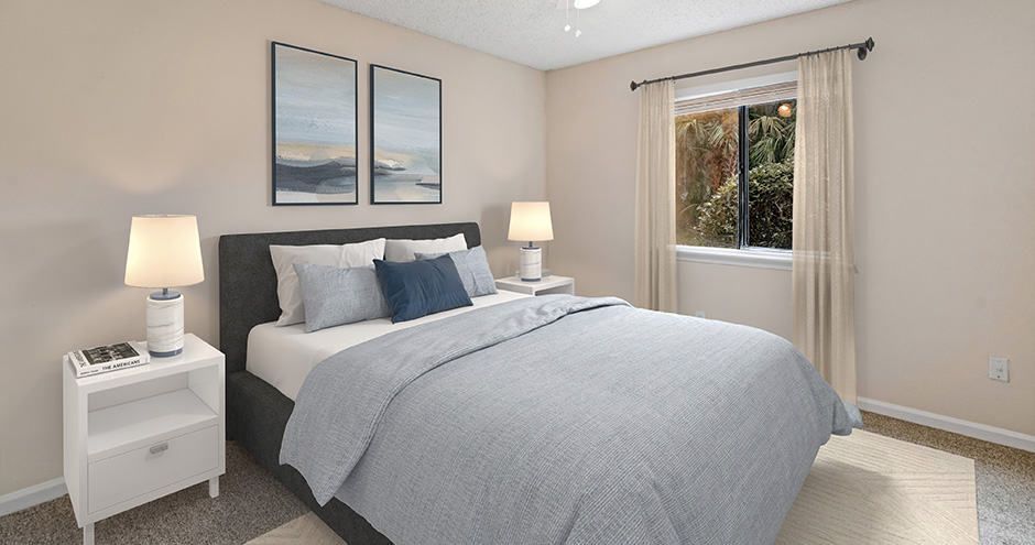 Bedroom with a bed, two nightstands, two lamps, two framed pictures, and a window with curtains.