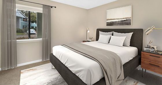 Bedroom with bed, nightstand, and window with curtains. Soft color scheme with a painting above the bed.