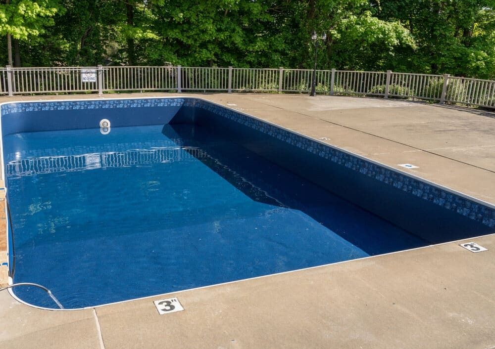 A Large Swimming Pool With a Fence Around It and Trees in the Background — Jaiden Tanners Water Supplies in Tyalgum, NSW