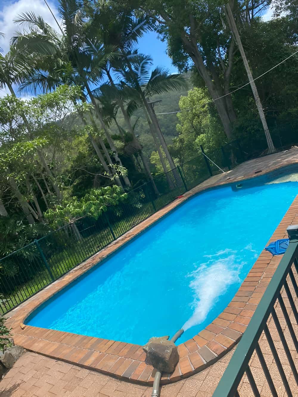 A Swimming Pool With Blue Water and Trees in the Background — Jaiden Tanners Water Supplies in Murwillumbah, NSW