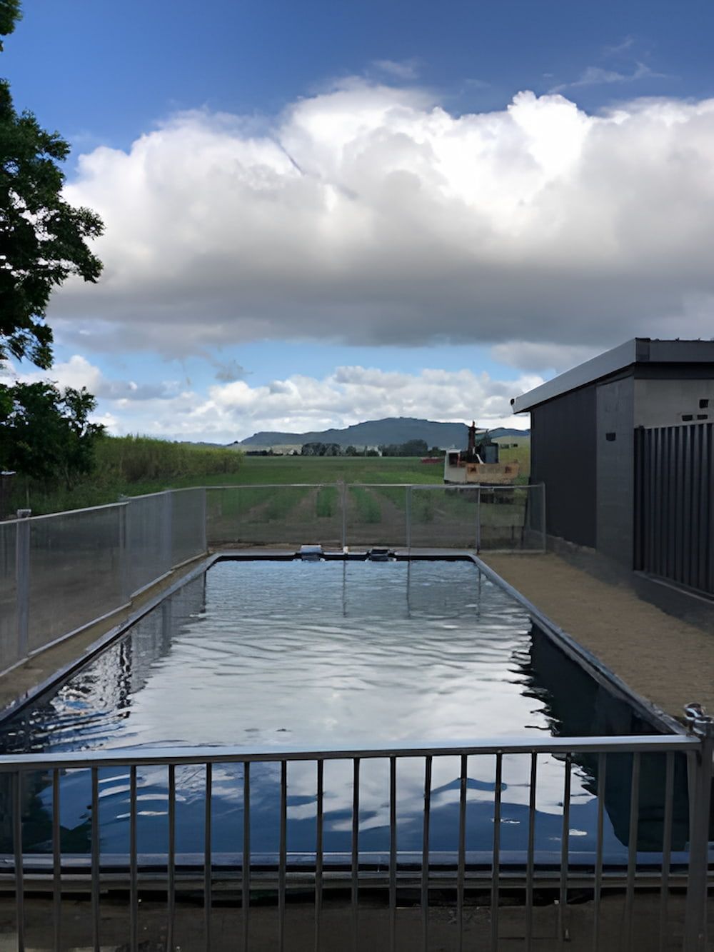 A Large Swimming Pool With a Fence Around It — Jaiden Tanners Water Supplies in Burringbar, NSW