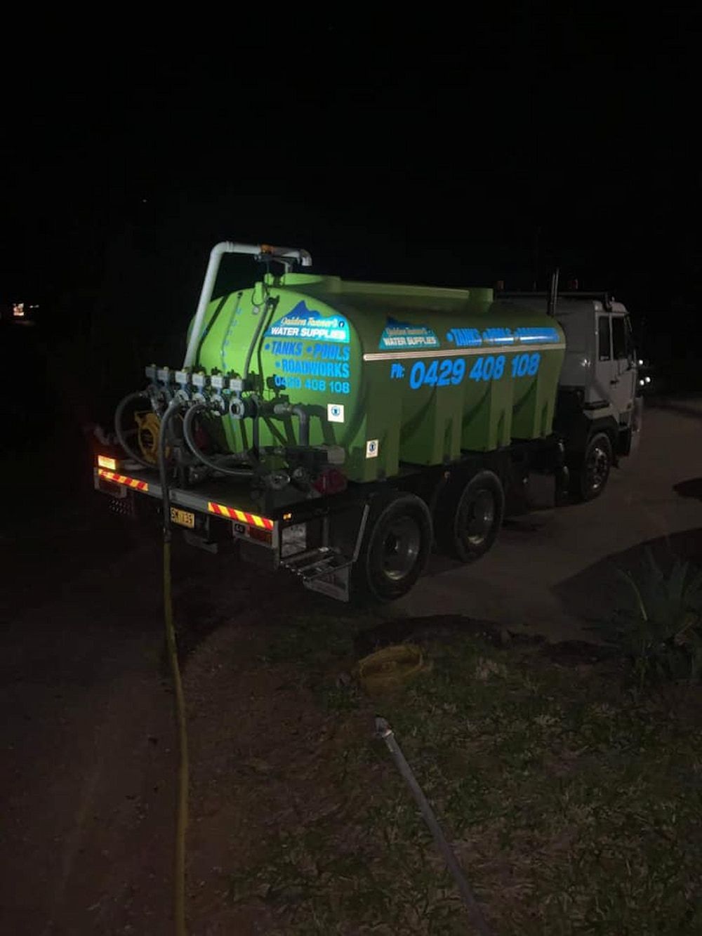 A Green Tanker Truck is Parked on the Side of the Road at Night — Jaiden Tanners Water Supplies in Tyalgum, NSW