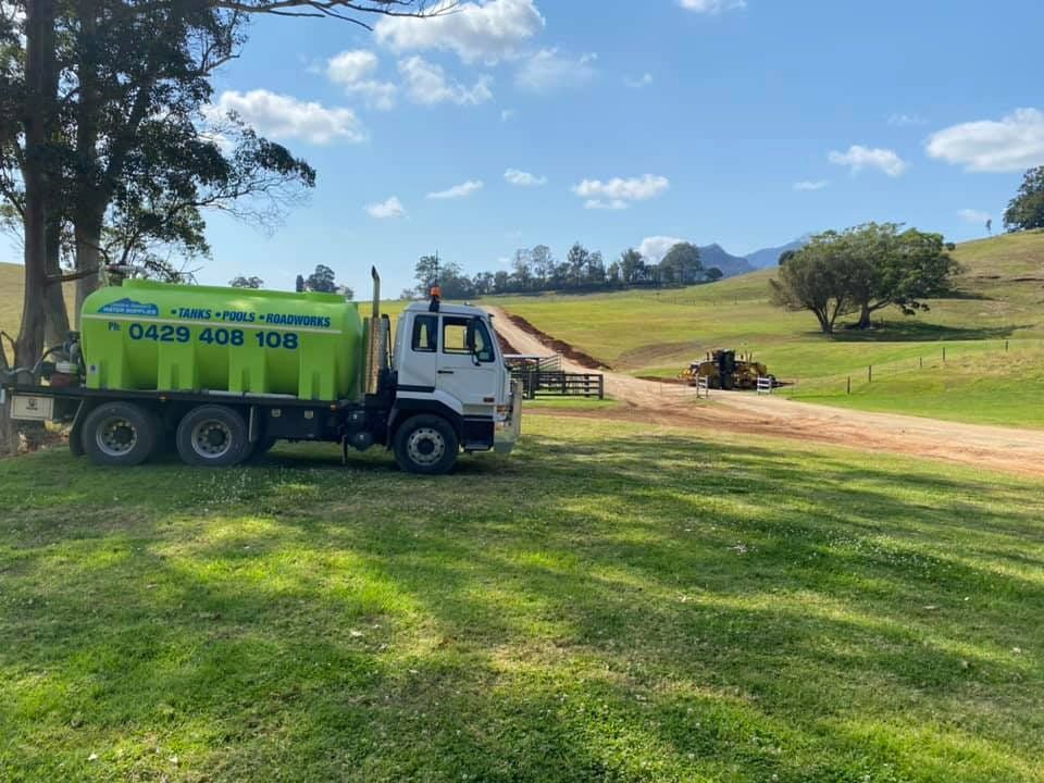 A Green and White Truck is Parked in a Grassy Field — Jaiden Tanners Water Supplies in Mullumbimby, NSW