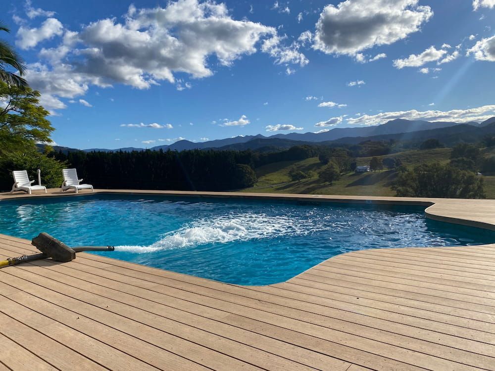 A Large Swimming Pool is Surrounded by a Wooden Deck — Jaiden Tanners Water Supplies in Murwillumbah, NSW