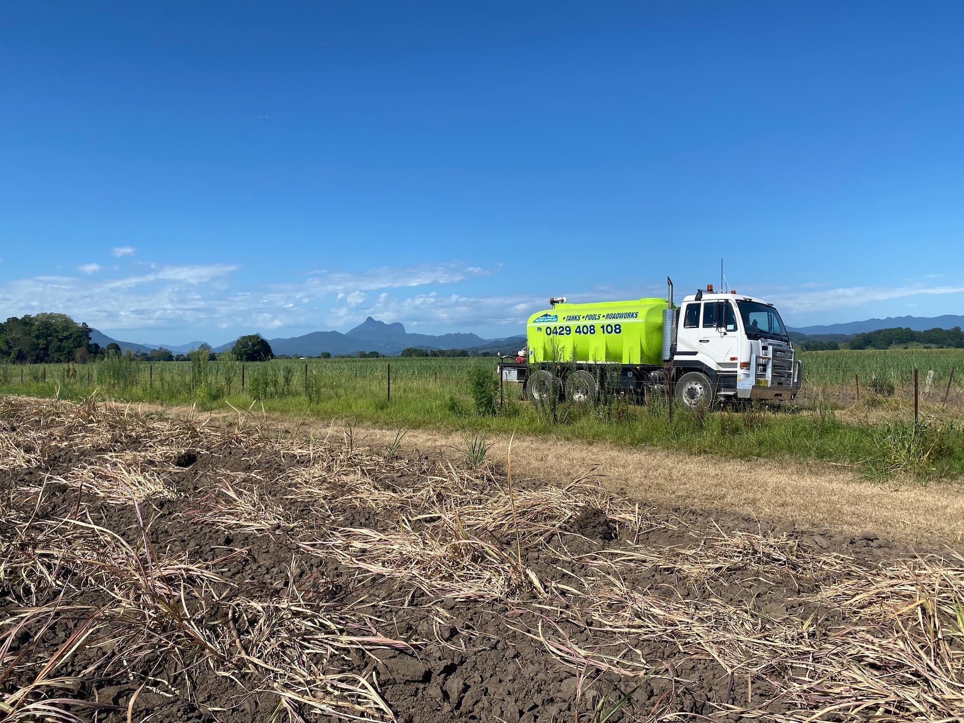 Water Truck Parked In Field — Jaiden Tanners Water Supplies in Nimbin, NSW