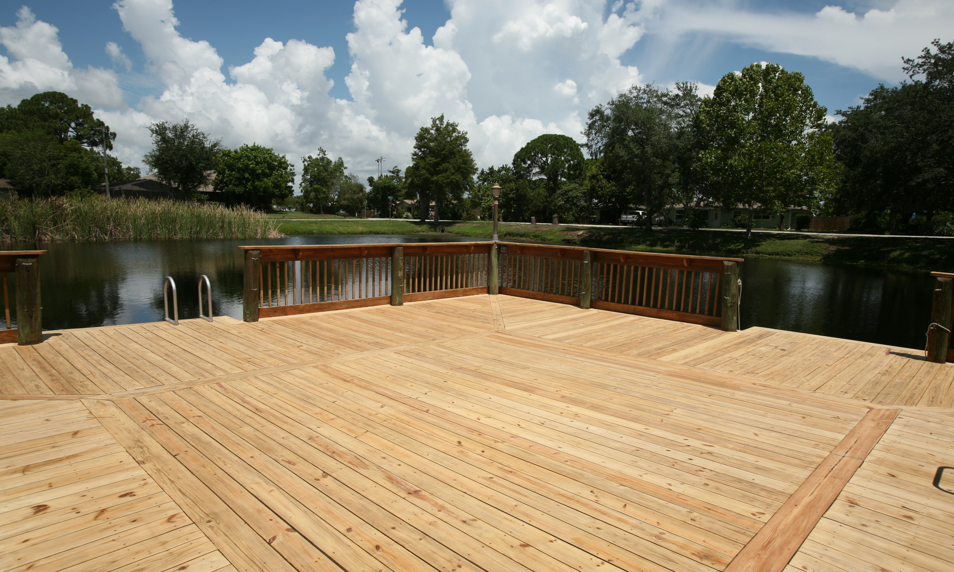 A photo of a deck built right next to a small pond in Athens, GA. The deck is massive in size.