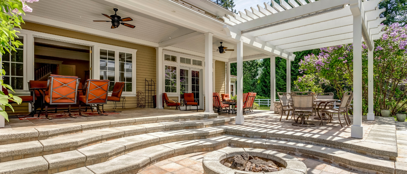 beautiful photo of a backyard deck and stone patio that has a warm welcoming rustic feel.