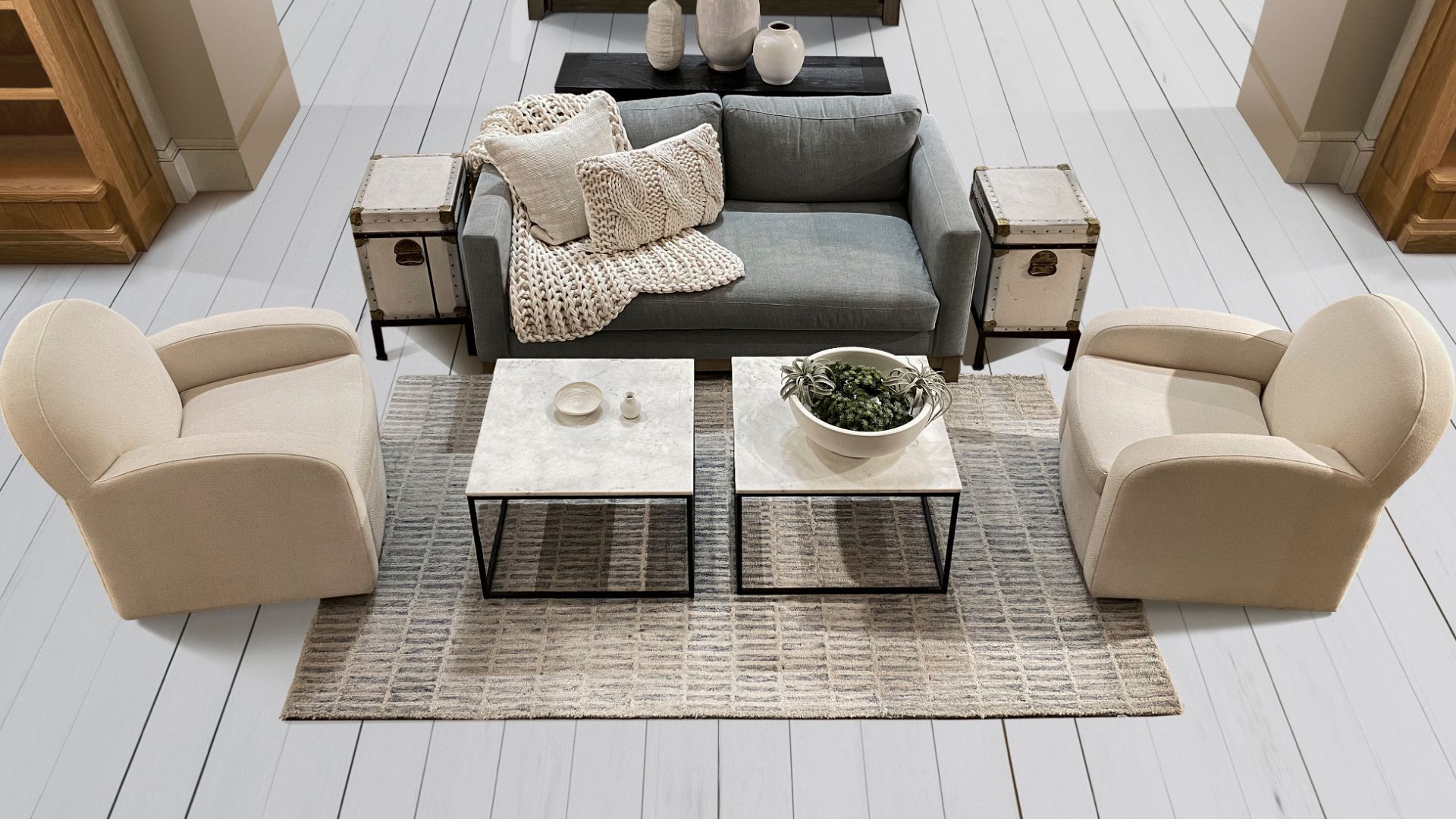 Modern outdoor deck in Athens, GA, featuring elegant seating options and minimalistic decor. The space includes a comfortable gray sofa adorned with textured throw blankets, two plush beige armchairs, and two marble-topped coffee tables placed on a woven rug. Complementing the setup are side tables with rustic charm, showcasing decorative vases. This serene deck offers a perfect blend of style and comfort, providing an inviting area for relaxation and socializing in the pleasant outdoor atmosphere of Athens.