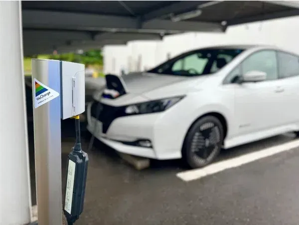 EV充電中の車とWeCharge対応のEV充電コンセント