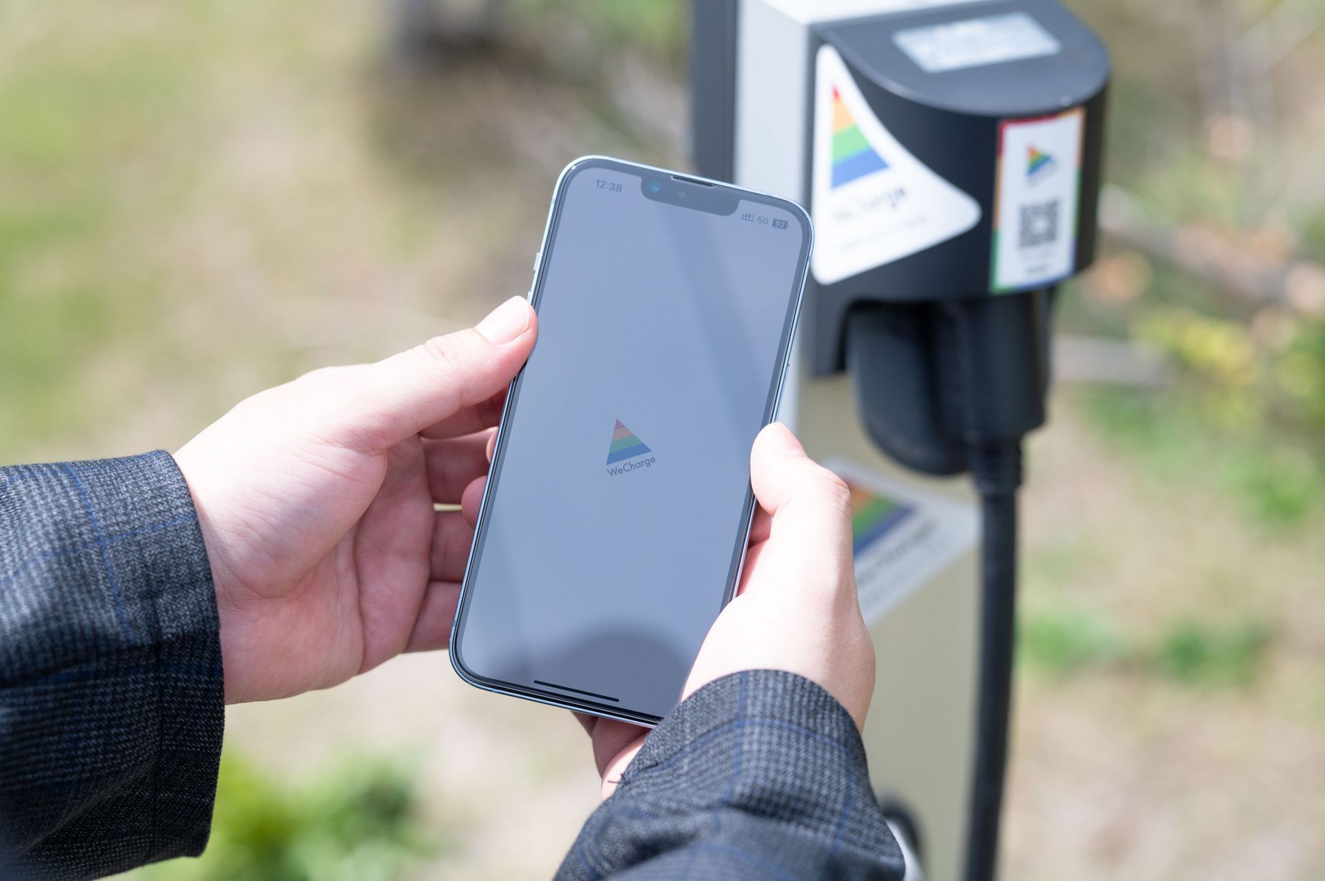 WeChargeの充電コンセントにWeChargeアプリをかざしてQRコードを読んでいるところ