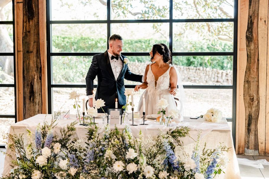 Newlyweds share a kiss under falling confetti in an outdoor wedding; the groom dips the bride.
