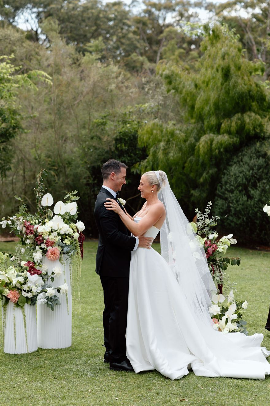 Bride and groom standing together outdoors in a garden wedding ceremony