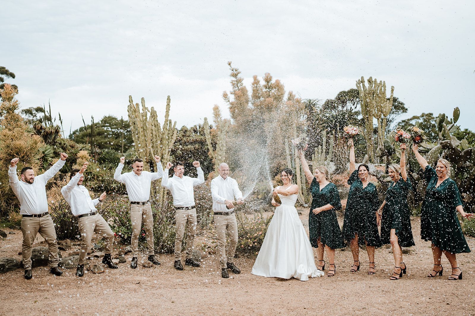 Wedding party celebrating with confetti outdoors. Couple and attendants, formal attire.