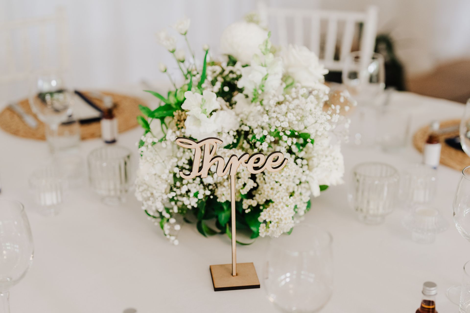 White floral centerpiece with a table number 