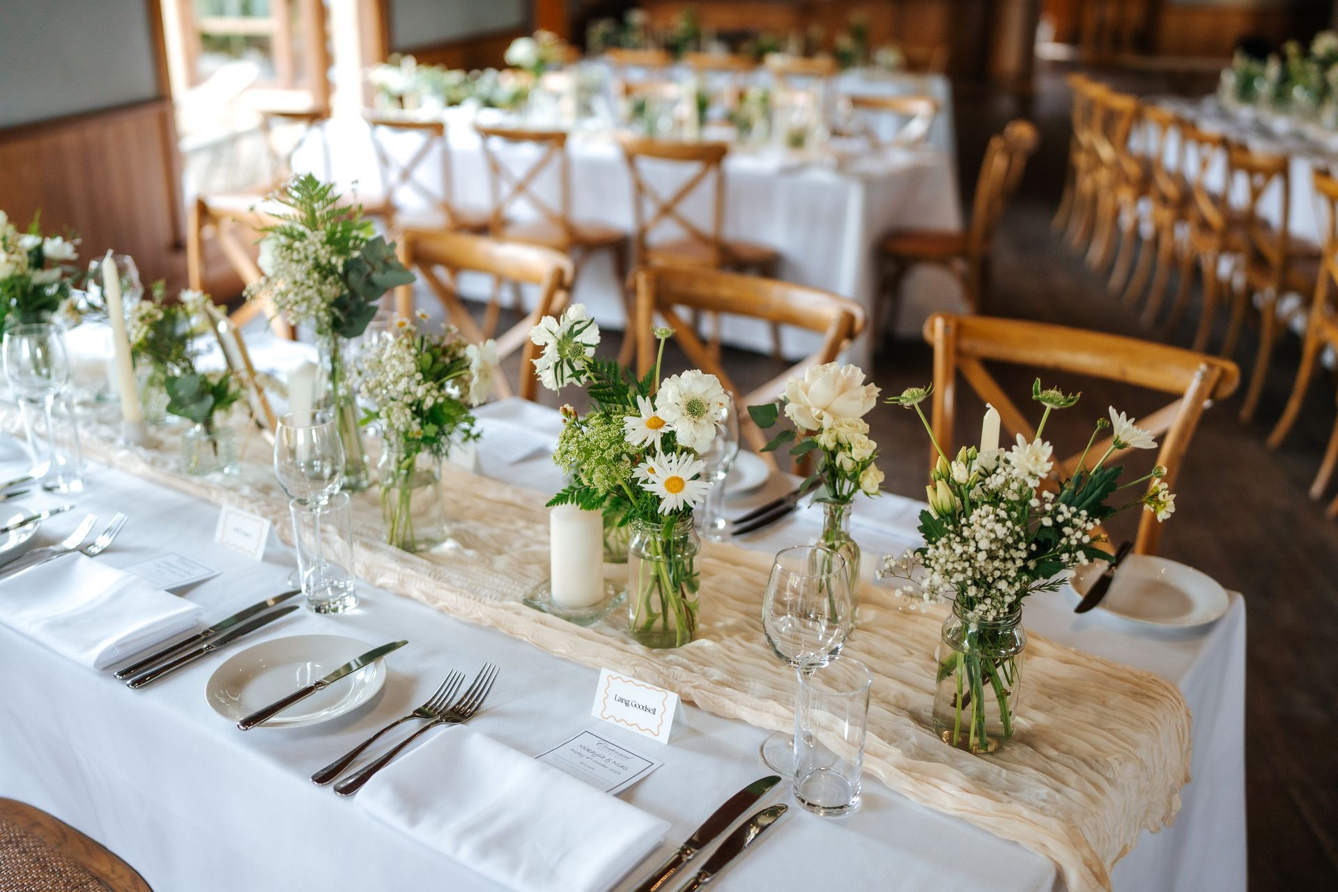 Elegant wedding reception table setting with floral centerpieces.