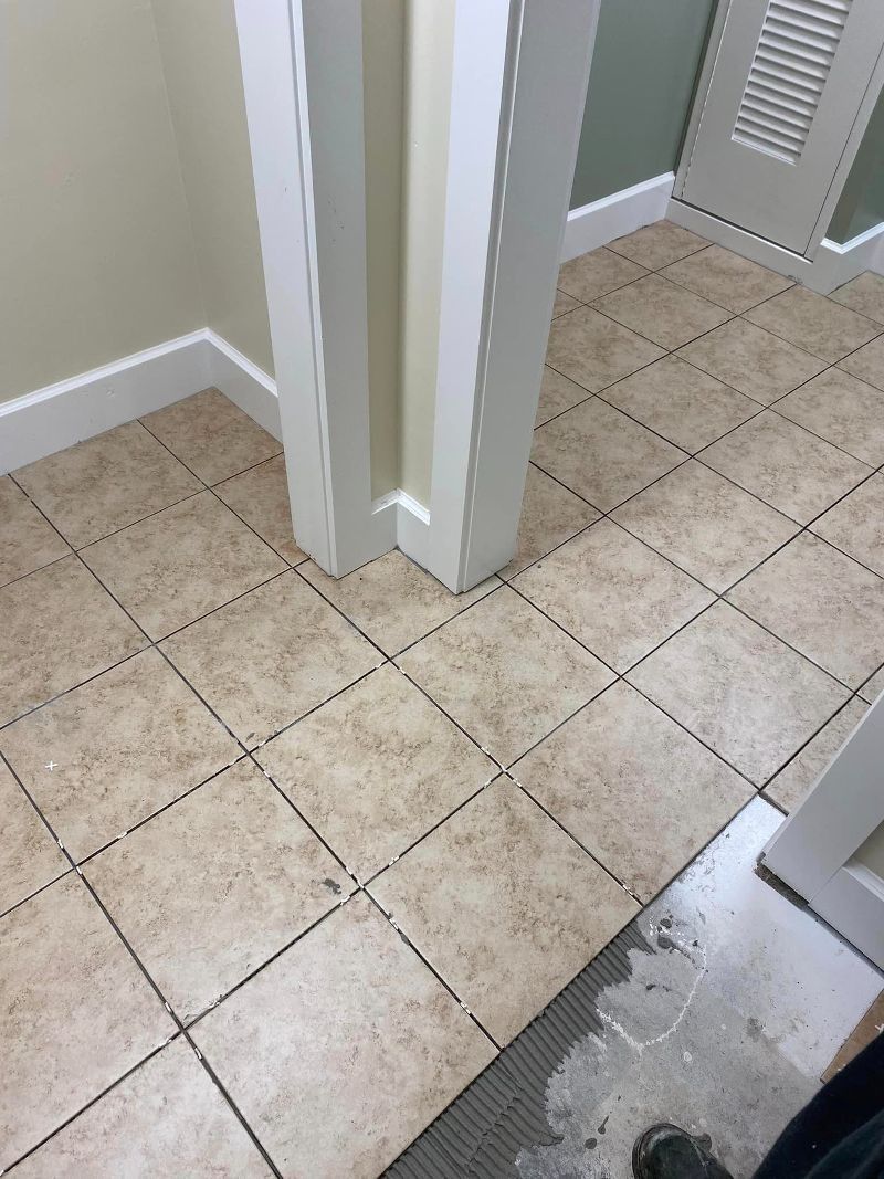 Tiled hallway floor with white walls and a louvered closet door, viewed from a doorway