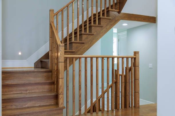 A wooden staircase with a wooden railing in a house.