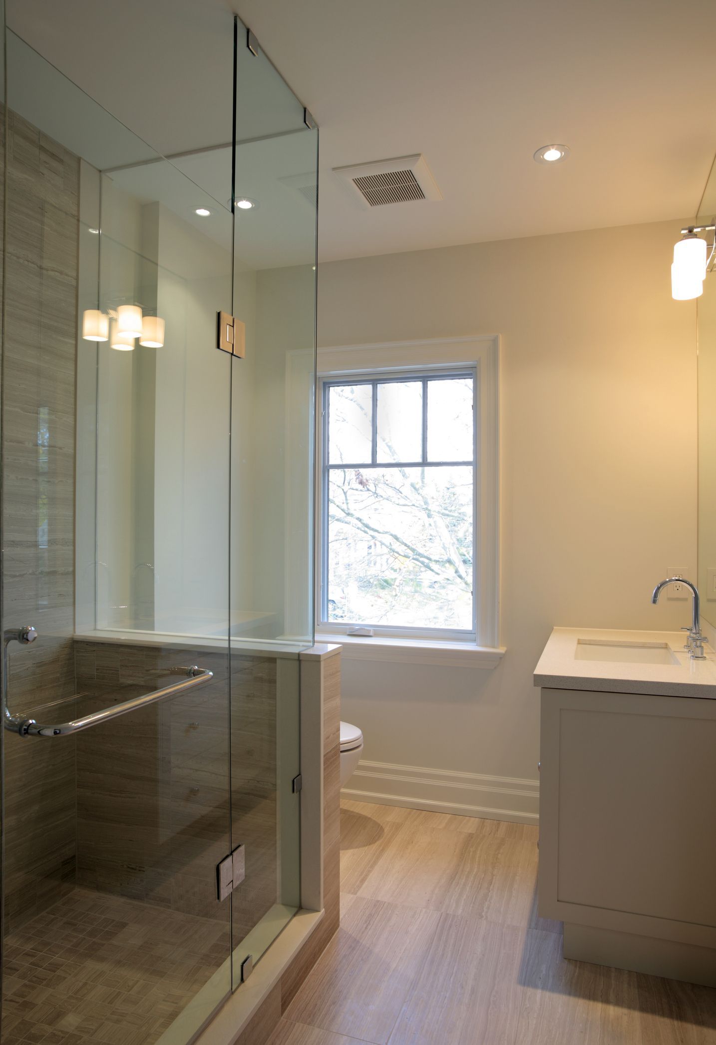 A bathroom with a walk in shower and a sink