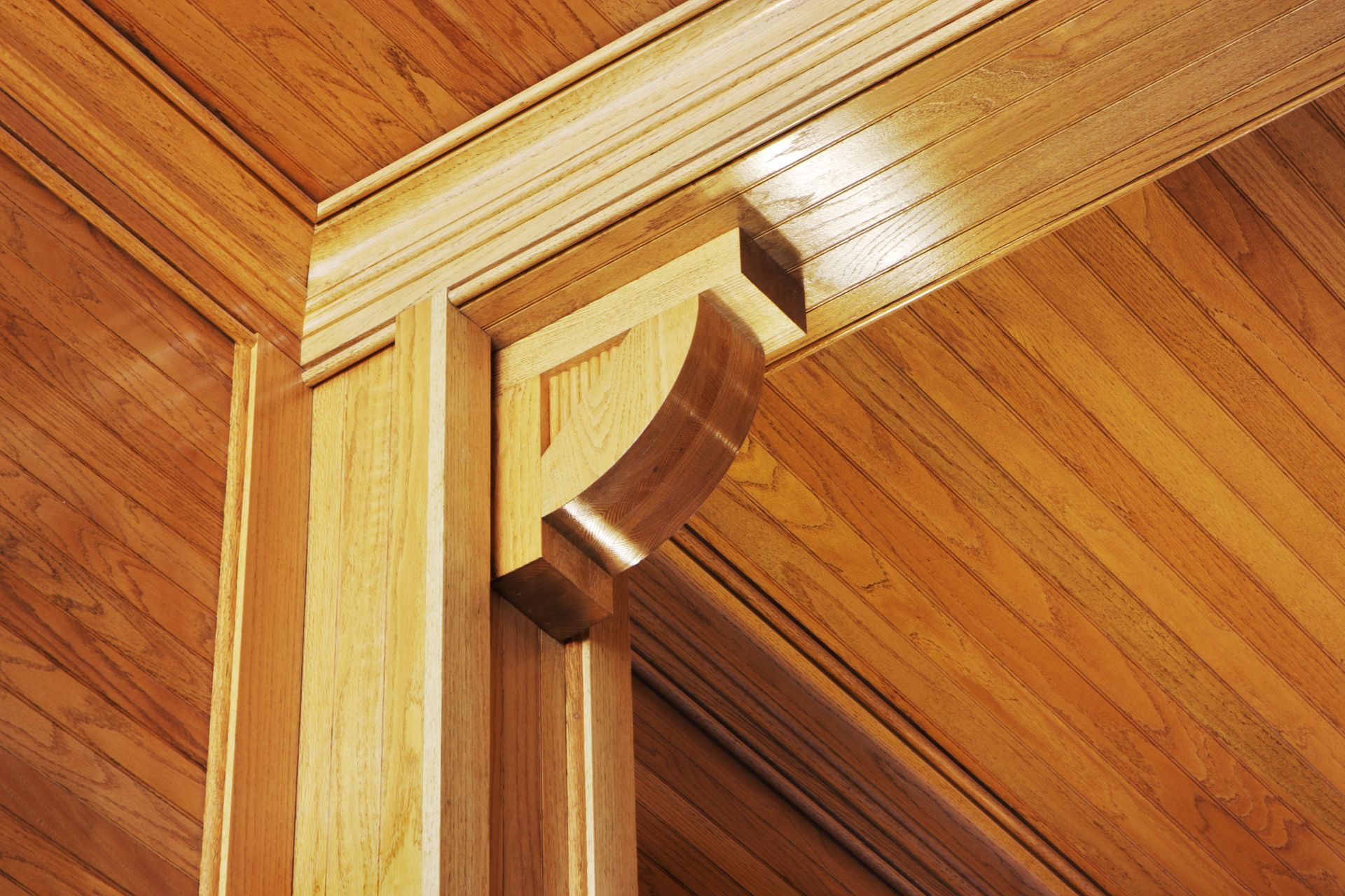 A close up of a wooden ceiling with a wooden corbel