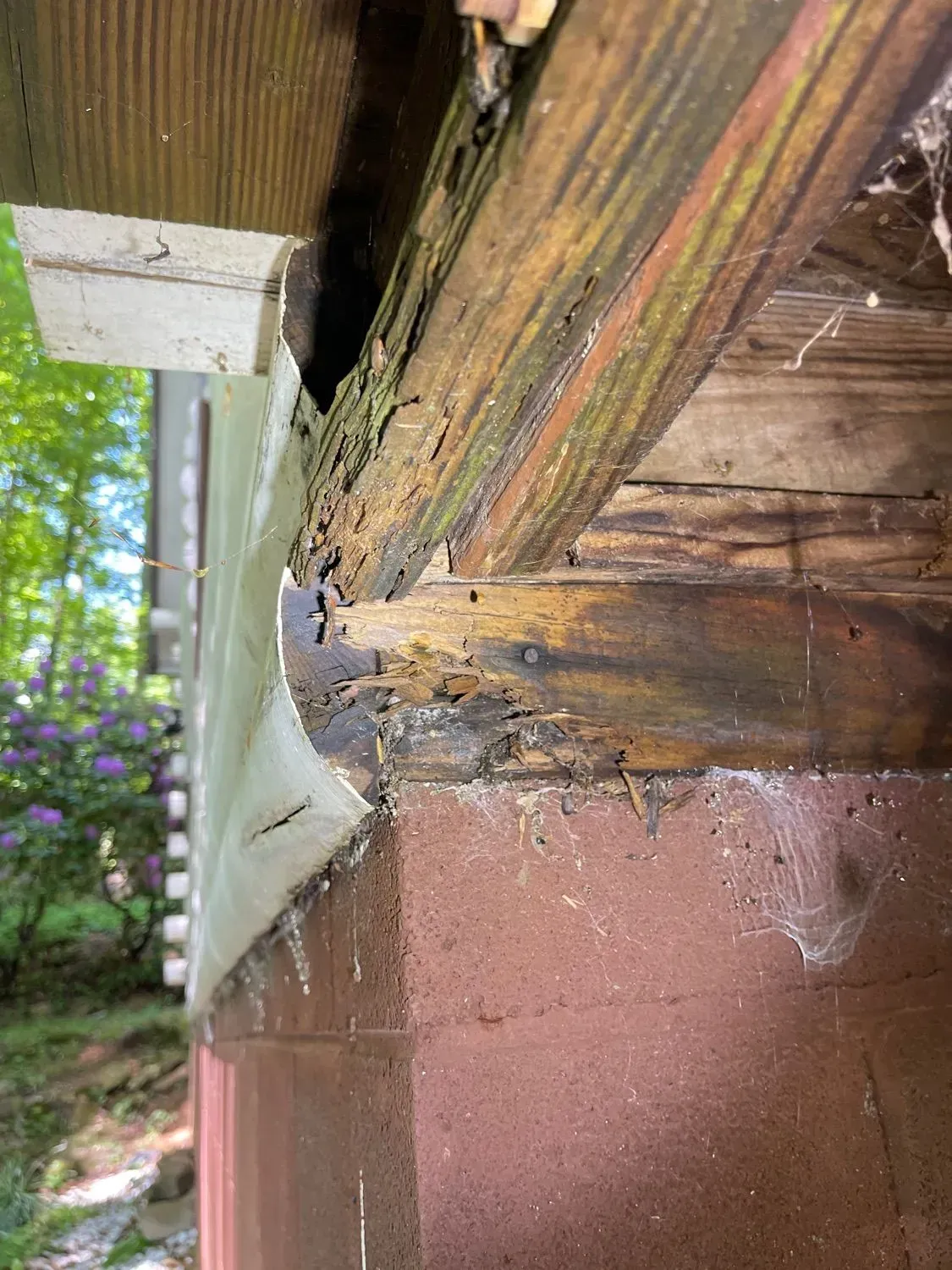 A close up of a wooden beam on a brick wall.