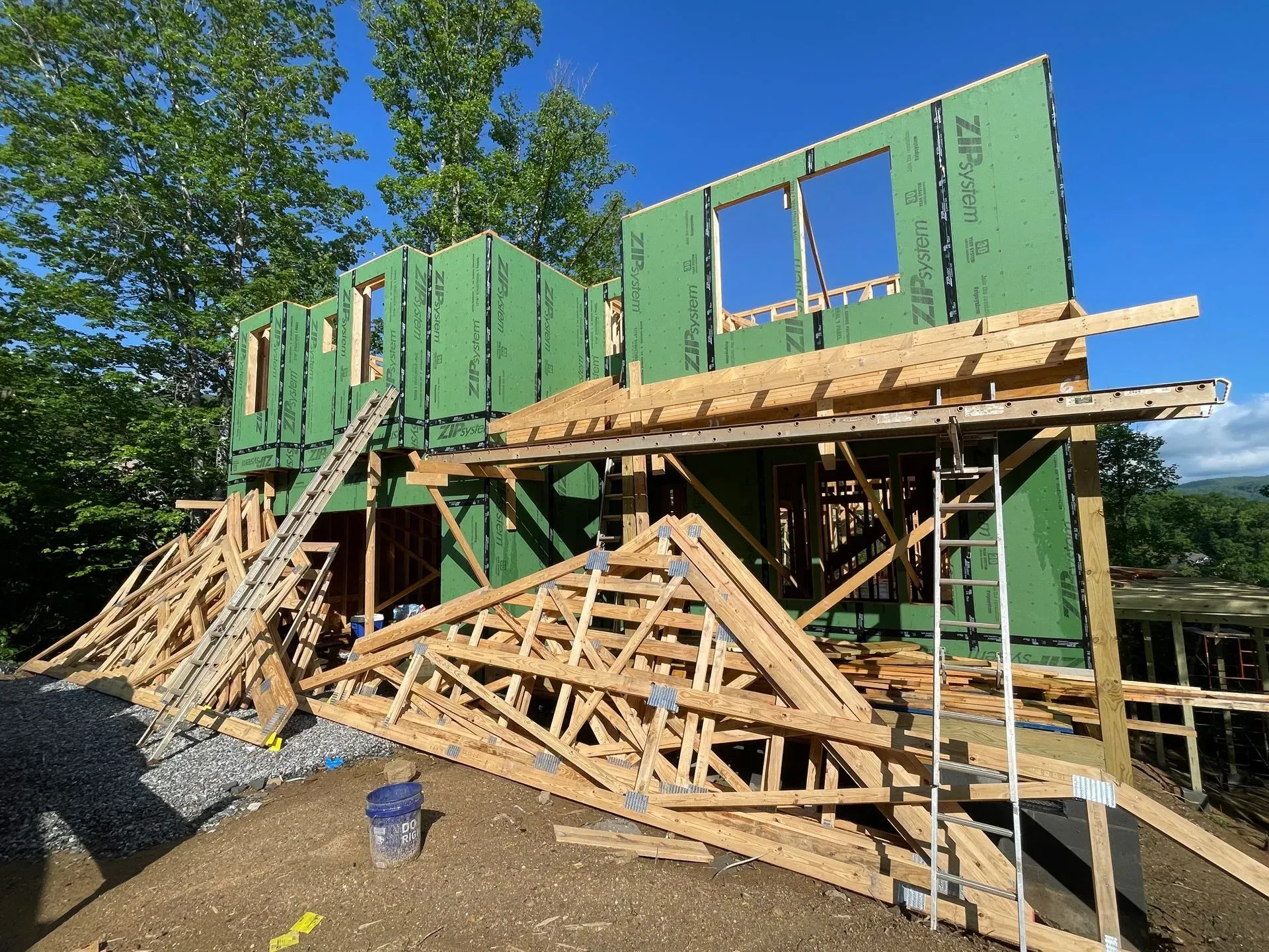 A house is being built with green walls and wooden beams.