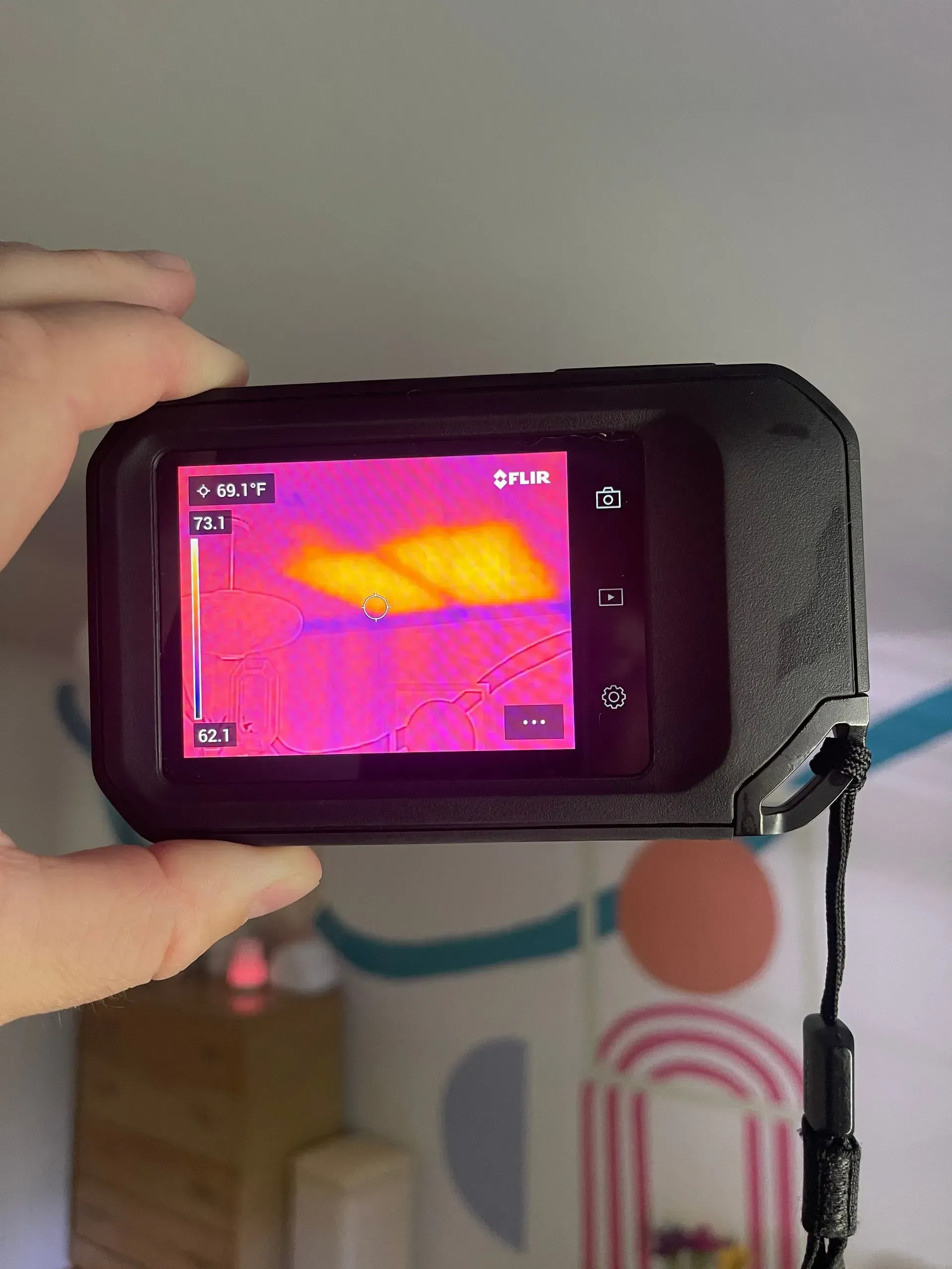 A person is holding a thermal camera in their hand.