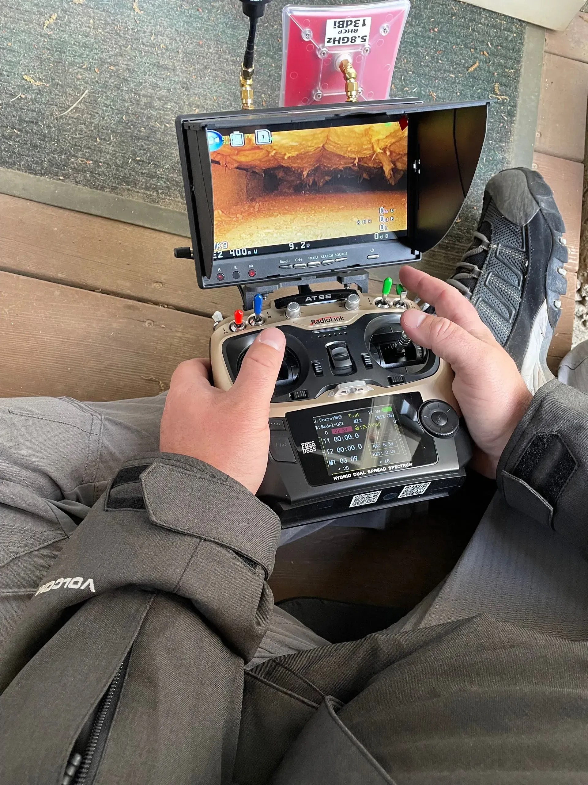 A person is sitting on a couch holding a remote control.