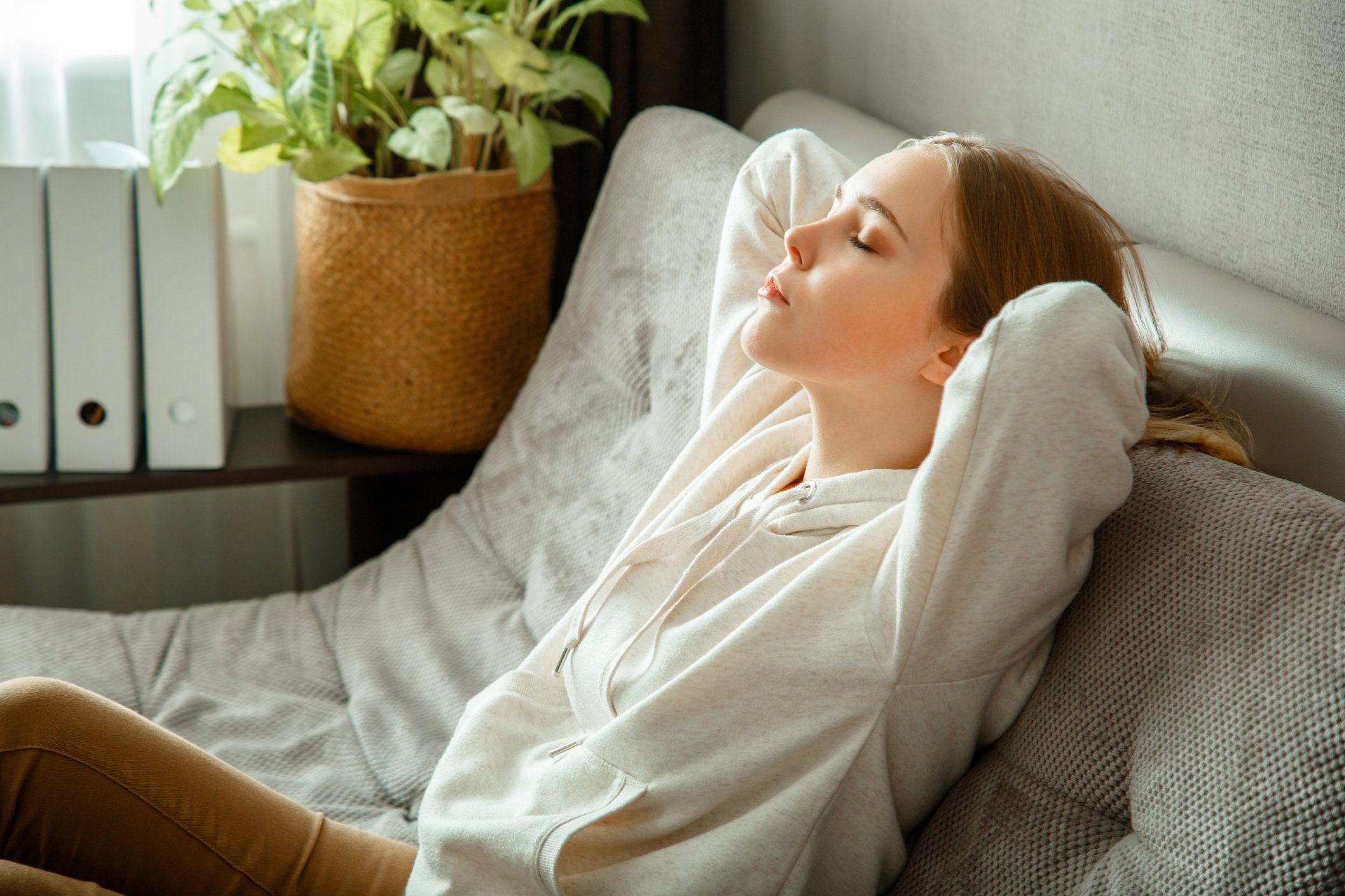 Relaxed woman laying back on couch with hands behind head folded | Build on Your Lot | Covell Communities | Chester, Maryland 21619