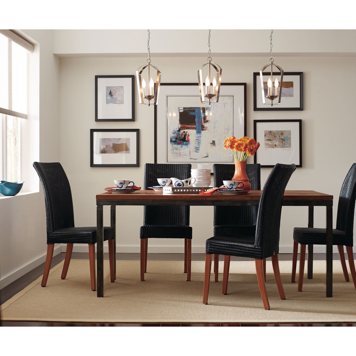 A dining room with a table and chairs and pictures on the wall