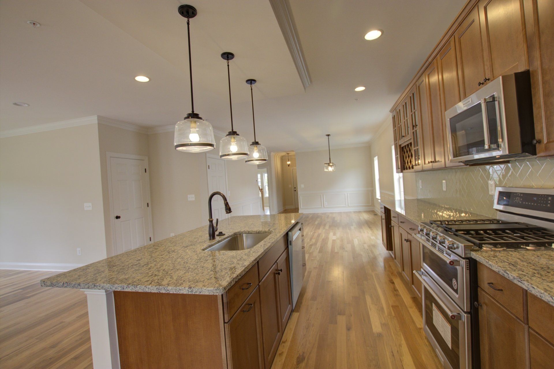 A kitchen with granite counter tops , stainless steel appliances , and wooden cabinets.