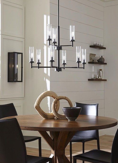 A dining room with a table and chairs and a chandelier hanging from the ceiling.