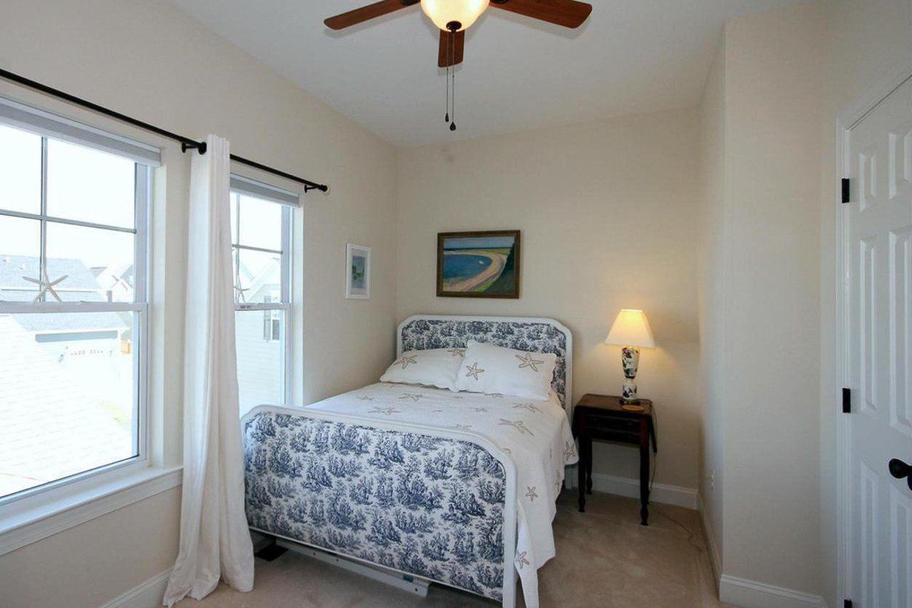 A bedroom with a bed and a ceiling fan