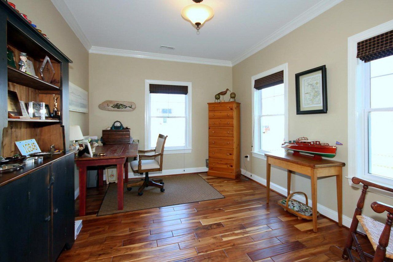 A room with hardwood floors and a desk and chair