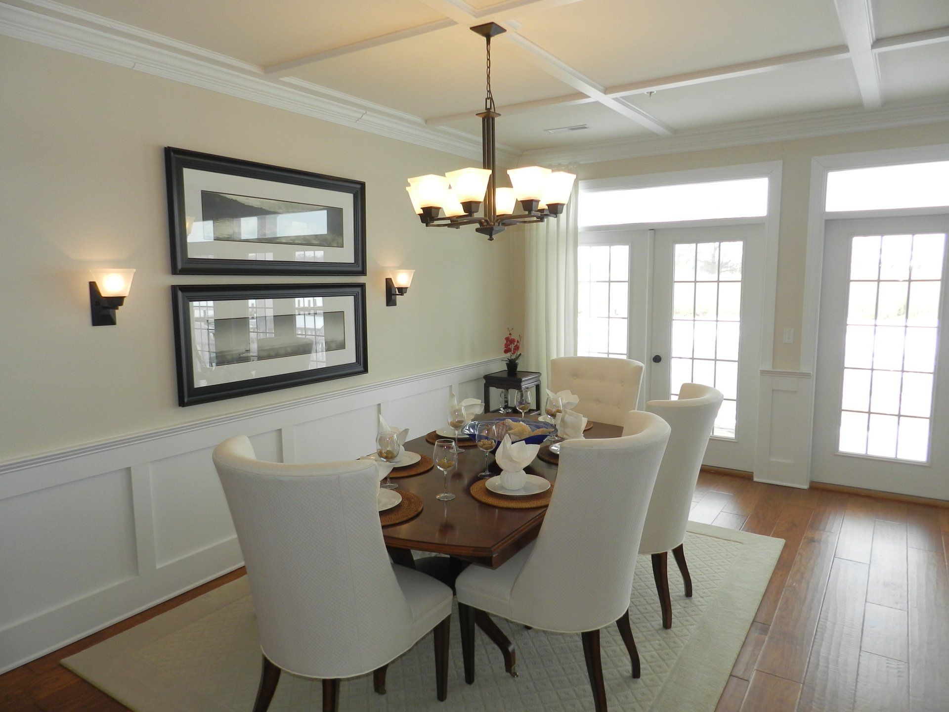 A dining room with a table and chairs and a chandelier