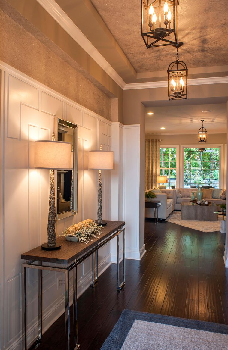 A hallway in a house with a table and lamps
