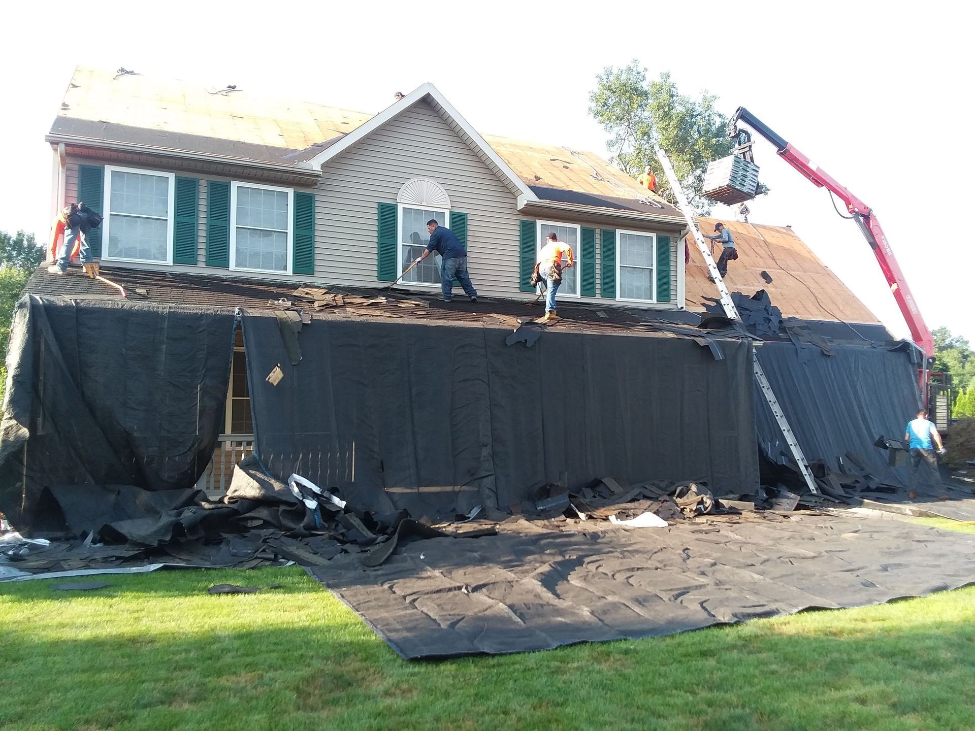 A house is being remodeled with a crane on top of it.