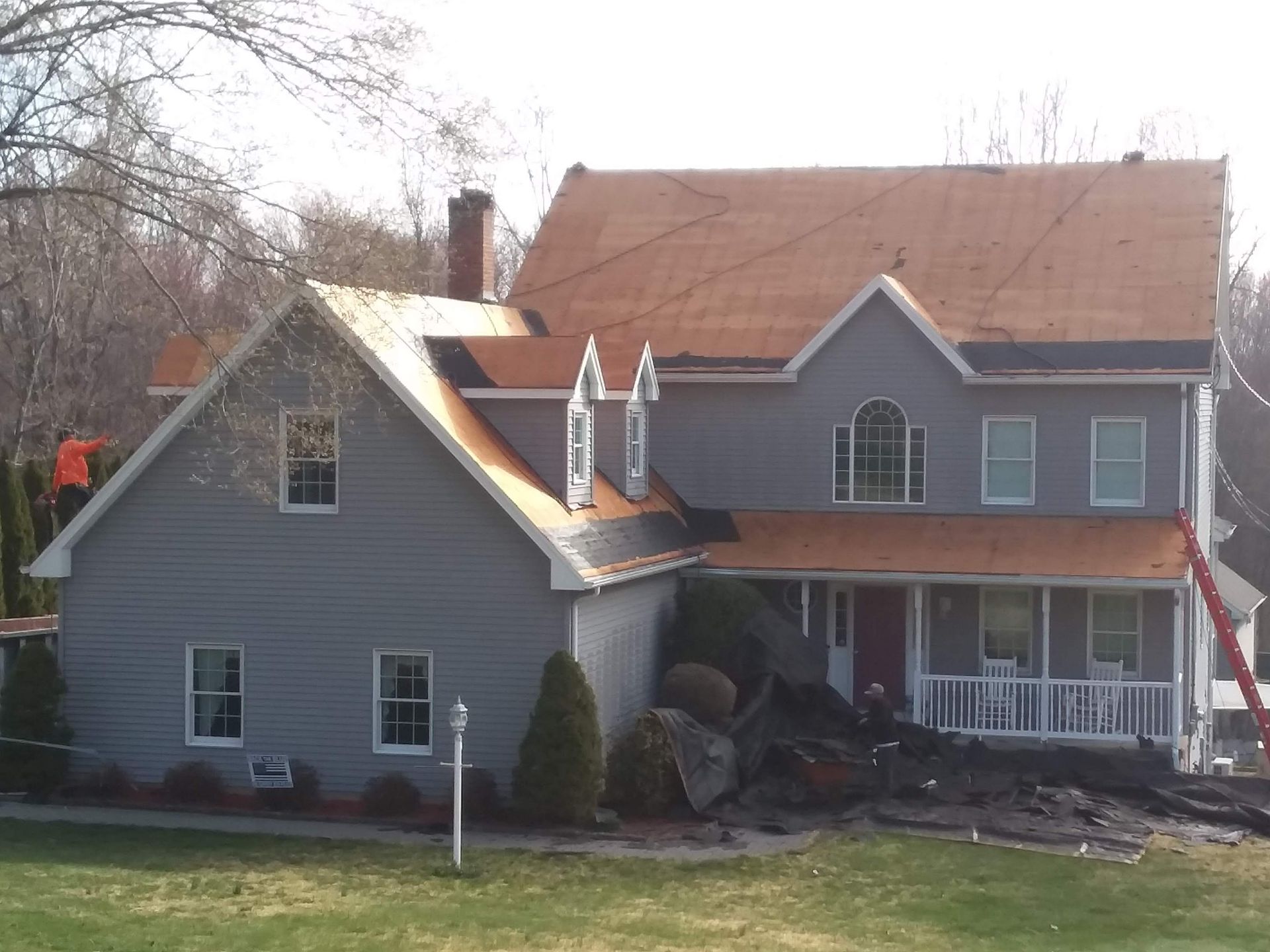 A large house with a red roof is being remodeled