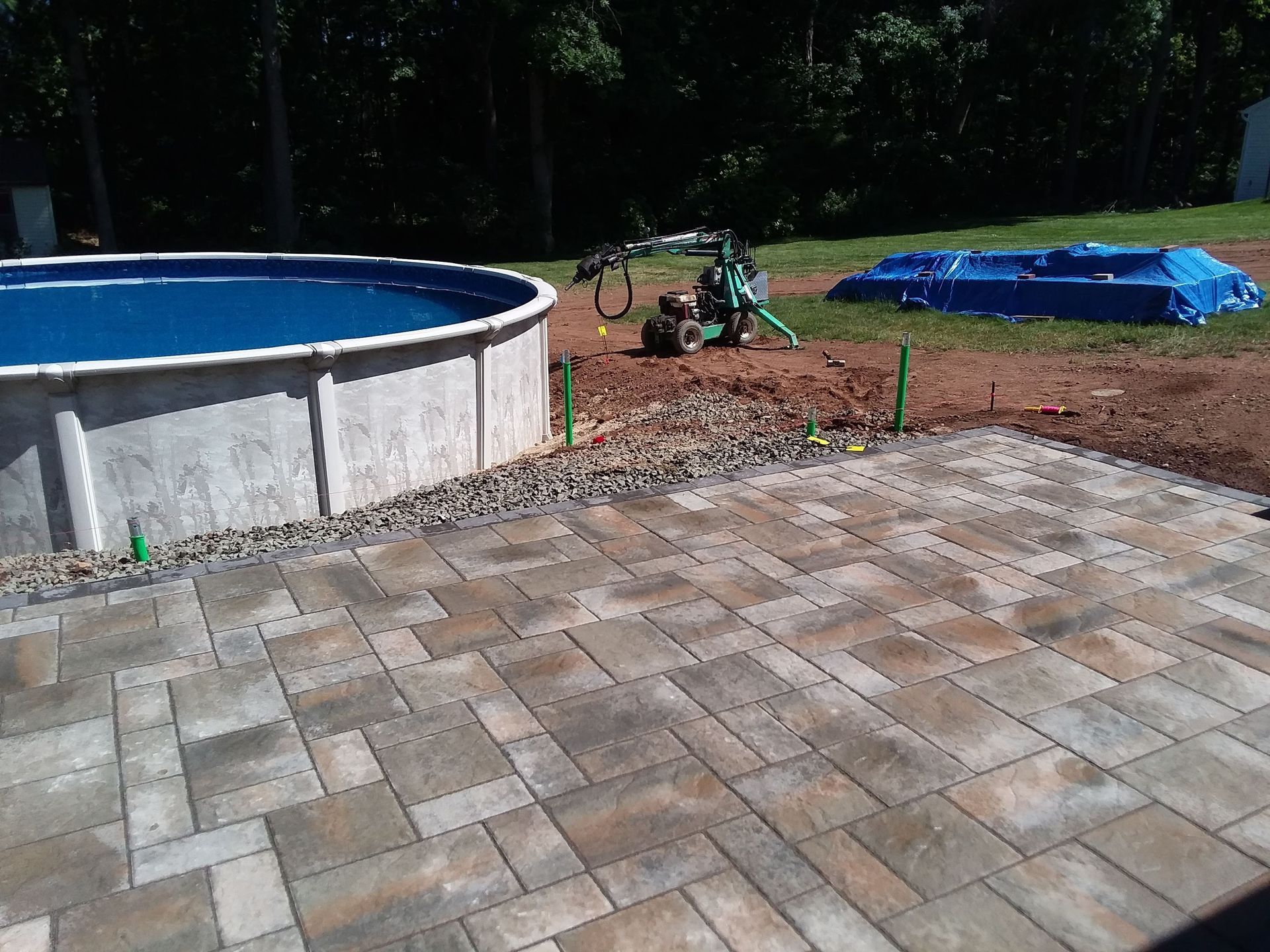 A swimming pool is being built next to a patio.