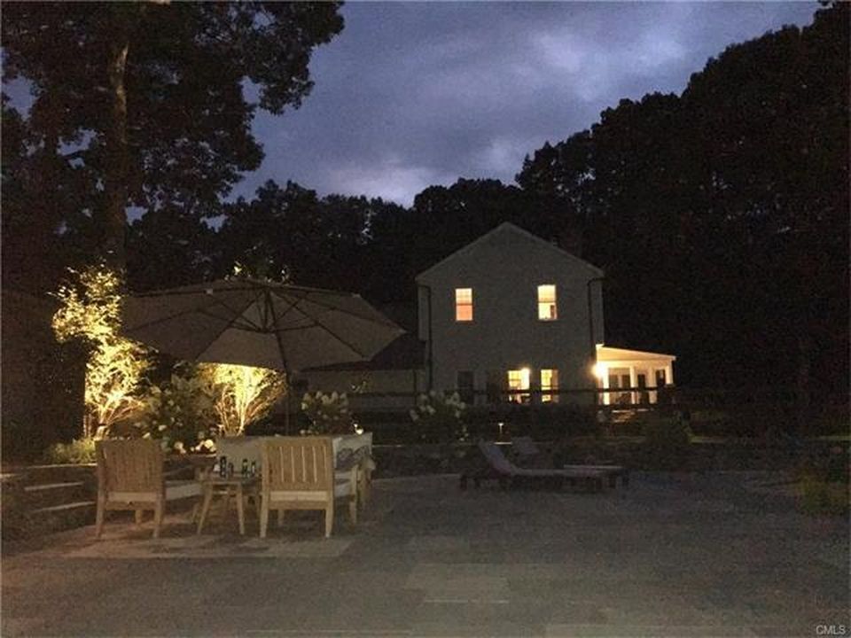 A house with a lot of windows is lit up at night