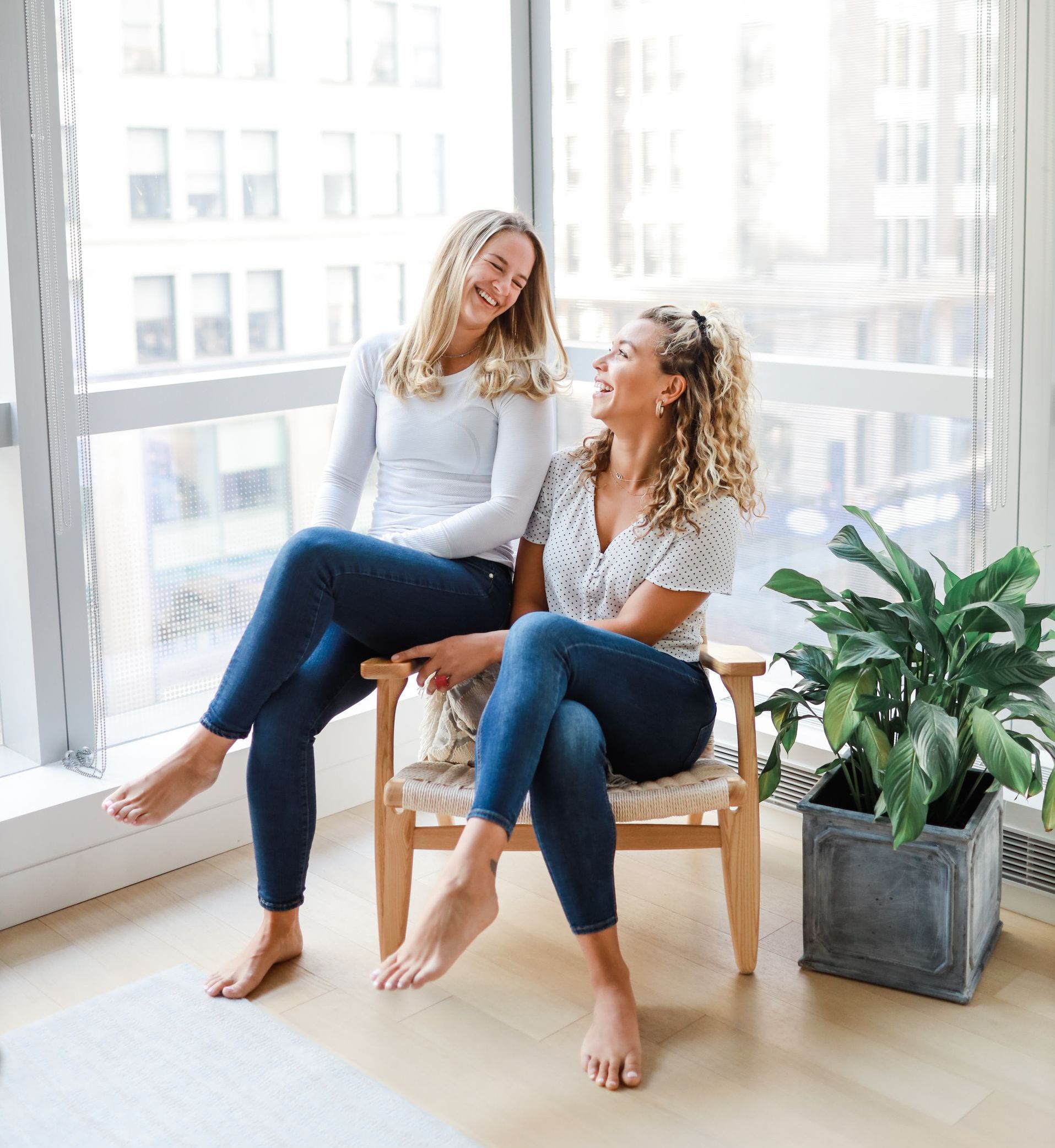 Two women are standing next to each other with their hands on their hips.