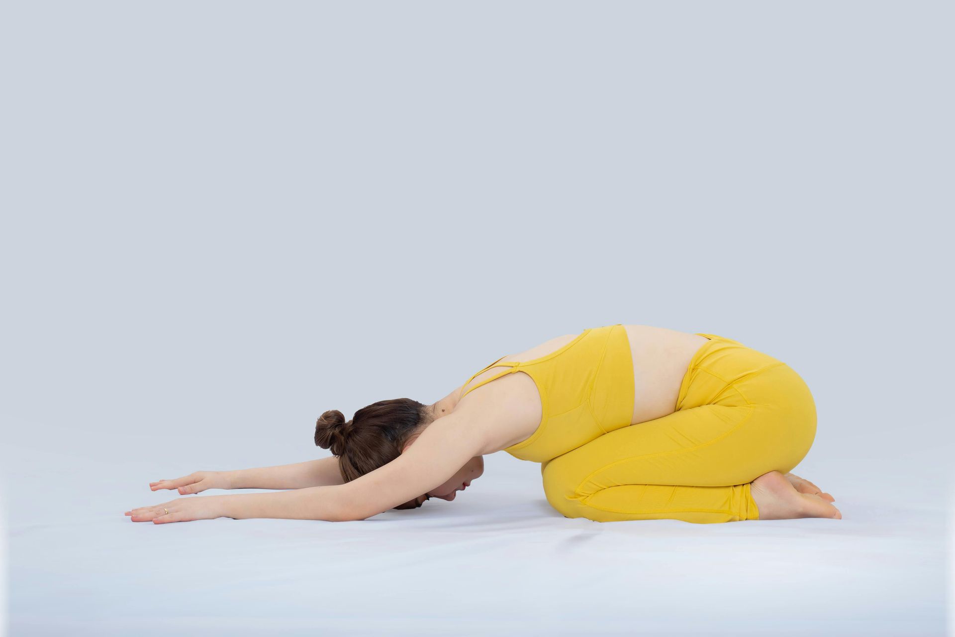 A woman is kneeling down in a yoga pose.